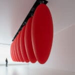 eight suspended red ovoids by SpY dance in pendular sequences