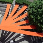 bright orange fabric panels fan out above university’s amphitheater in japan