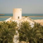lighthouse-like tower rises amid white walls of residence by TAEP/AAP in kuwait