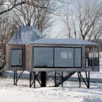 prefab residence by delordinaire balances on stilts to preserve natural terrain in quebec
