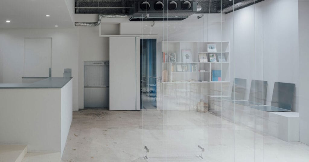 1975 men’s hair salon unfolds within transparent acrylic frame