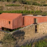 ancient wall envelops pink house by stefano riva in portugal