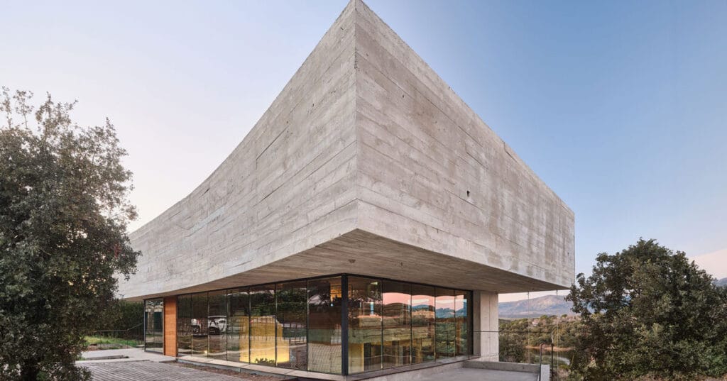 concrete-enveloped casa roble adapts to madrid’s terrain with its curved facade
