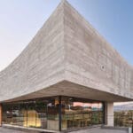 concrete-enveloped casa roble adapts to madrid’s terrain with its curved facade