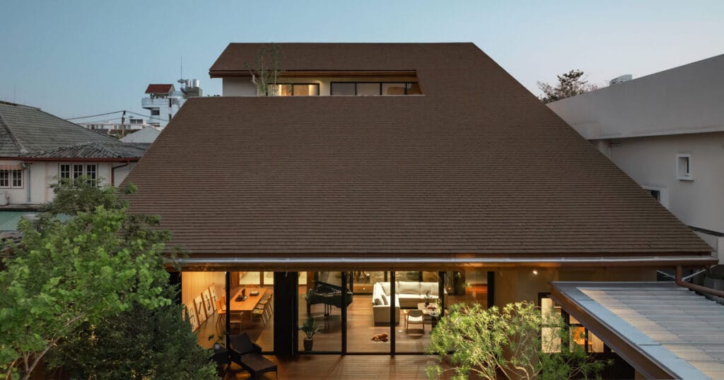 cut-out sloped roof covers three-layered residence in thailand