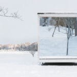 tyyni sauna’s mirrored glazing reflects the snowy finnish landscape